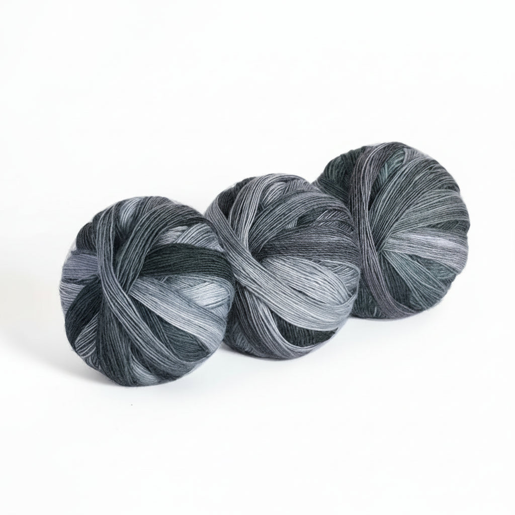 Three skeins of gray yarn with color code 612 and weight information on a white background.