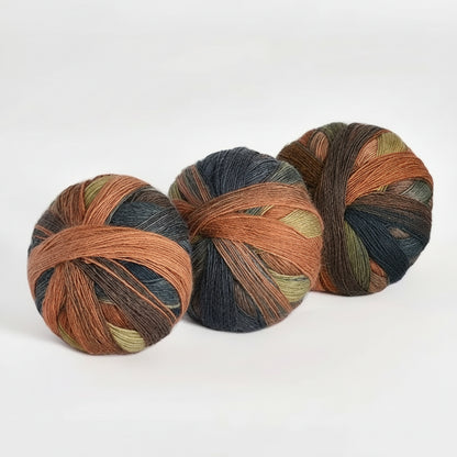 Three skeins of multicolored yarn on a white background with text indicating color code and weight.